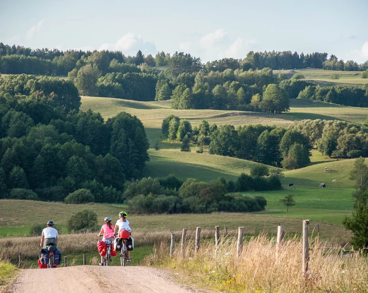 Grafika promocyjna wydarzenia Kinderwyprawka wakacje na Pojezierzu Augustowskim — rowerowa przygoda dla rodzin